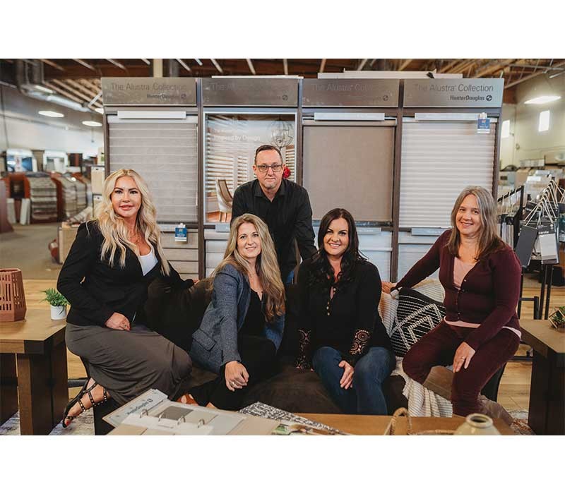 Dealership staff grouped together around a couch, posing for a photo